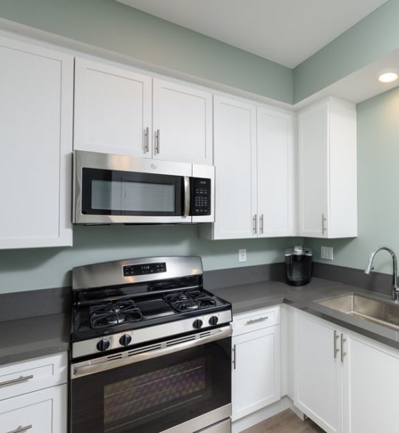 a kitchen with white cabinets and stainless steel appliances