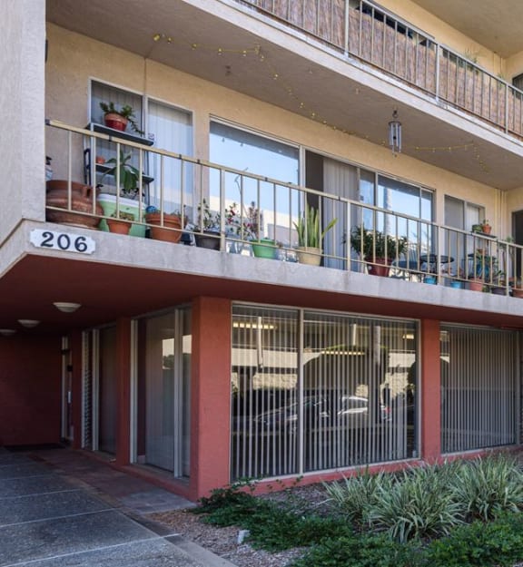 an apartment building with balconies and a sign in front of it