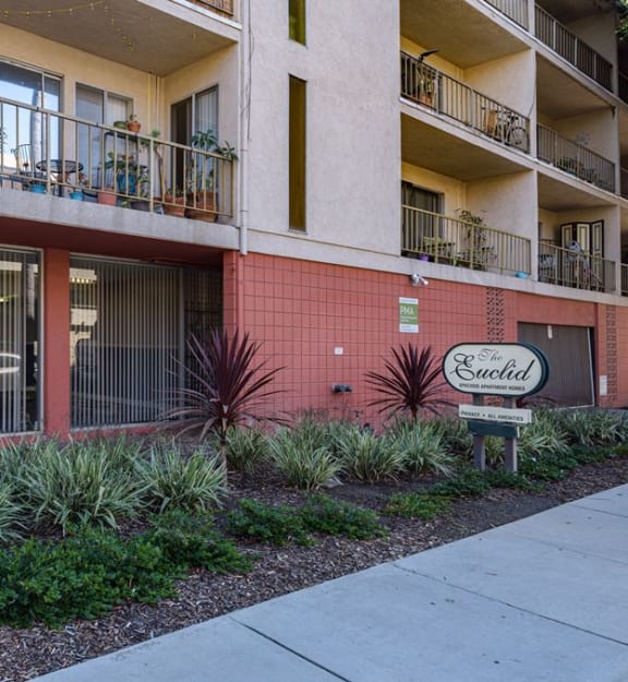 an apartment building with a sign in front of it