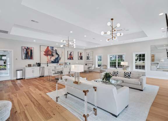 a clubroom with white sofas, a dinette, and are on the walls.