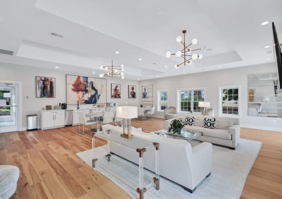 a clubroom with white sofas, a dinette, and are on the walls.