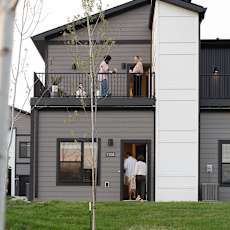 A house with a grey roof and a white garage door.