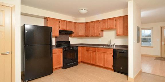 A kitchen with a black counter top and a white fridge.