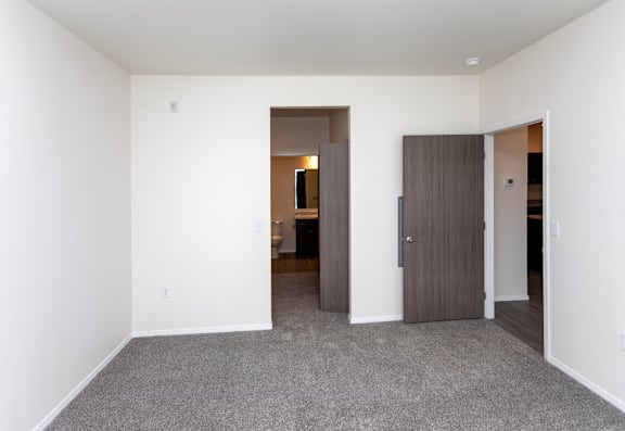A room with a ceiling fan and carpeted floor.