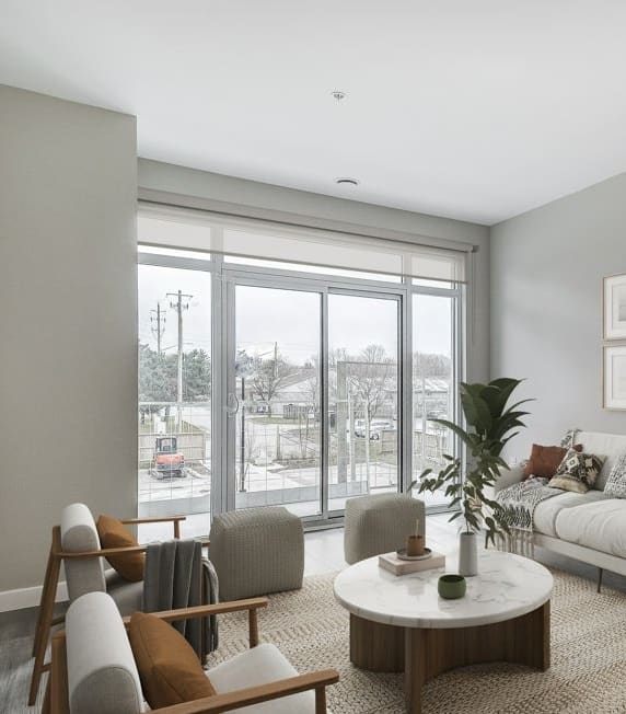 a living room with a white couch and a large window  at 101 Base Line Road West, London, ON