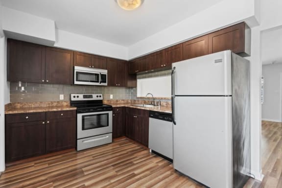 a kitchen with white appliances and wooden floors