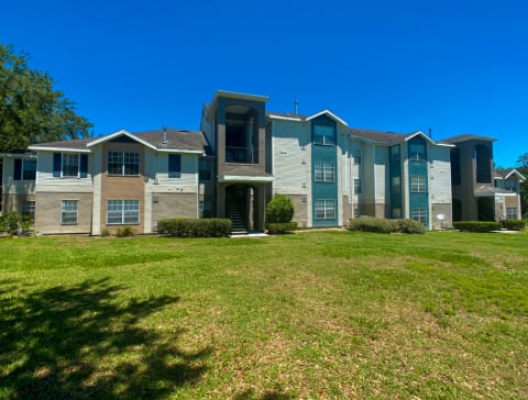 Apartment building exterior surrounded by native landscaping