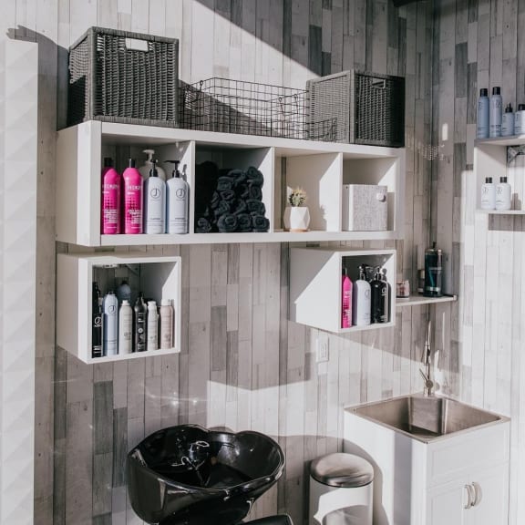 a bathroom with a sink and shelves on the wall at Versus, Calgary
