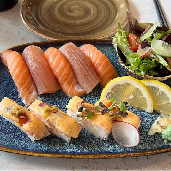 a plate of sushi with salmon and a salad at Versus, Calgary, Alberta, T2R 1A8