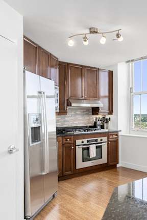 A kitchen with a granite counter top and a painting hanging on the wall at Residences Providence, Providence, RI