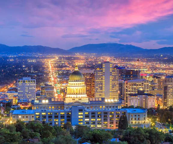 a city at night with the mountains in the background