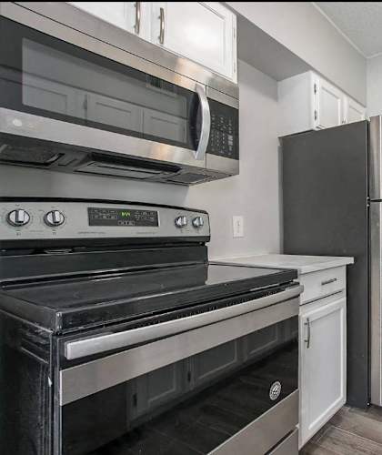 a kitchen with stainless steel appliances and a refrigerator
