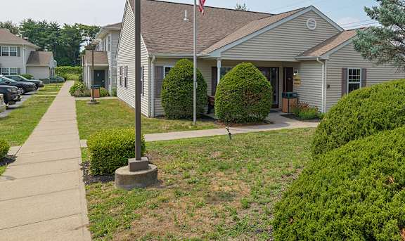 A sign for Birchwood Village is in front of a building.
