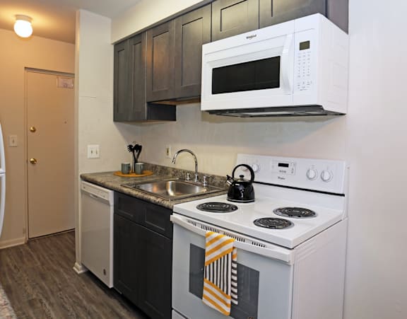 a kitchen with white appliances and a sink and a white microwave