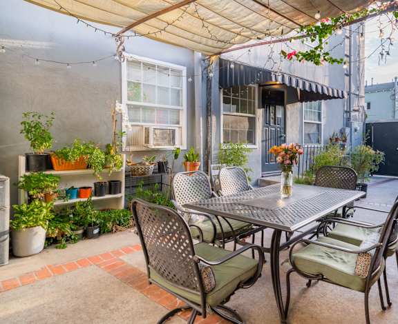 A patio with a table and chairs under a canopy.