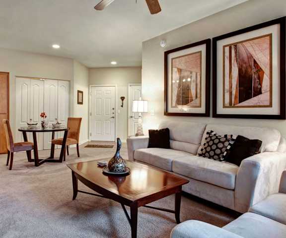 a living room filled with furniture and a ceiling fan