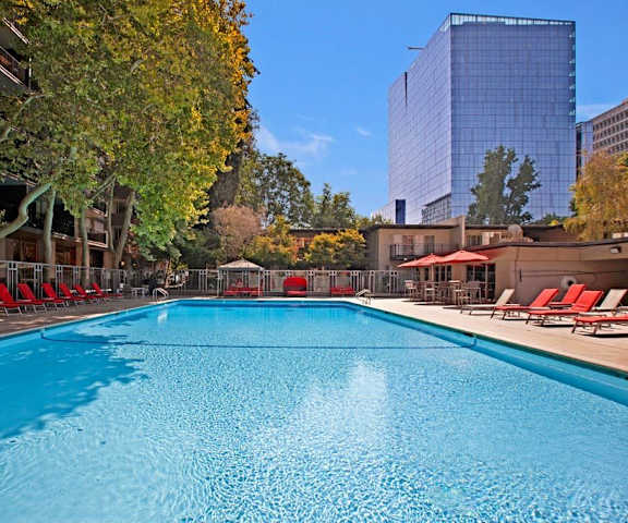 The outdoor pool with pool chairs, tables, and chairs at Capitol Towers - Towers and Villas.
