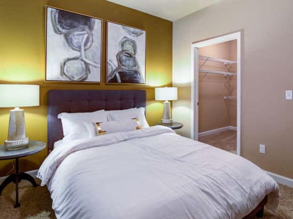 a bedroom with a bed and a closet  at The Retreat Apartment Homes, Williston, 58801