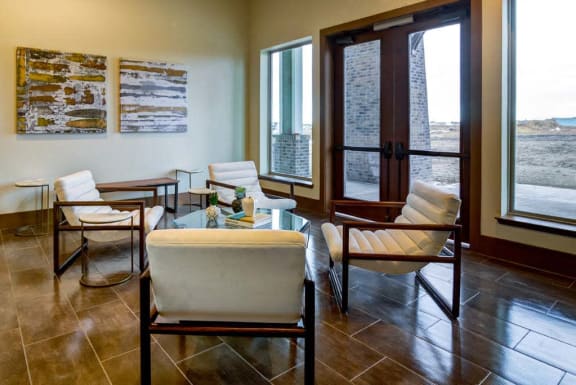 a living room with chairs and a glass table  at The Retreat Apartment Homes, North Dakota, 58801