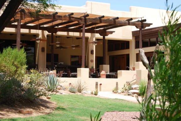 a patio with a pergola in front of a house