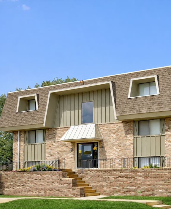 A modern house with a grey roof and a brick wall.