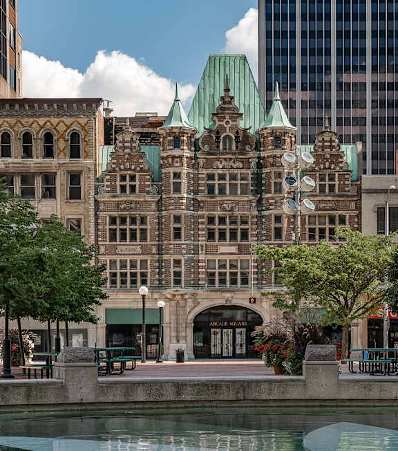 A large, ornate building with a green roof sits next to a body of water.