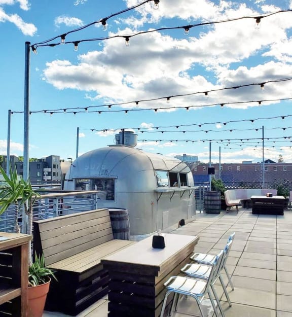 the roof terrace of the building has a barbecue grill and tables and chairs