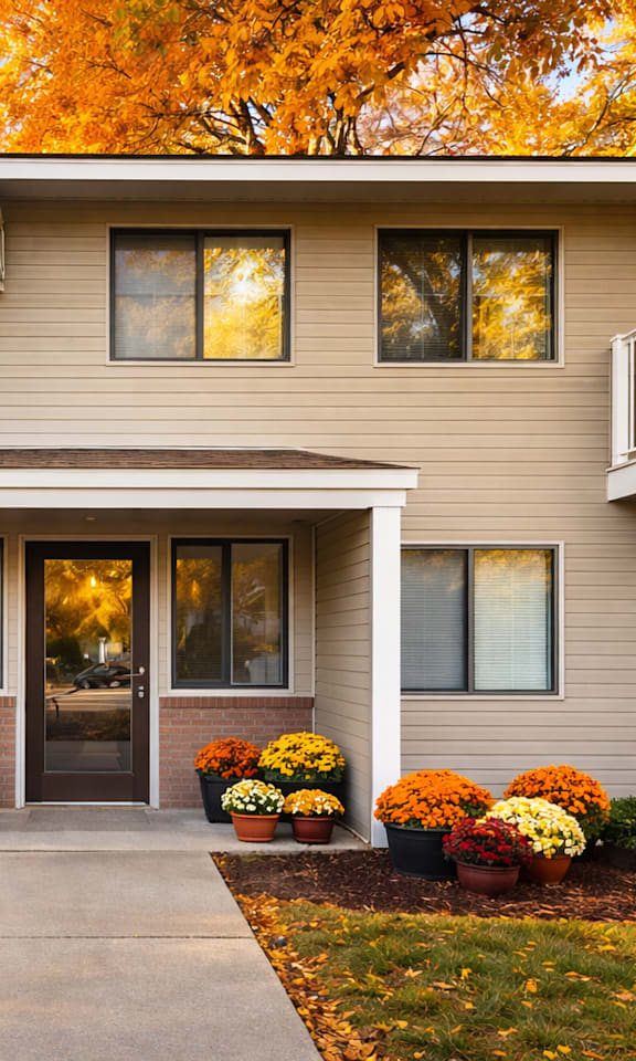 A house with a grey siding and a brown roof with a glass door and windows.