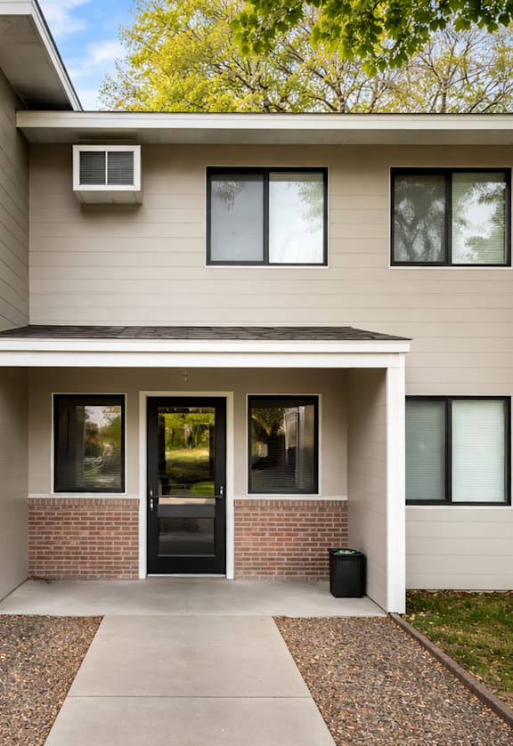 A modern house with a black door and a small window.