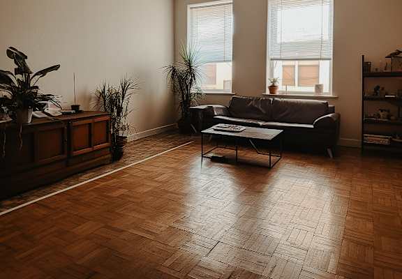 a living room with a couch coffee table and two windows