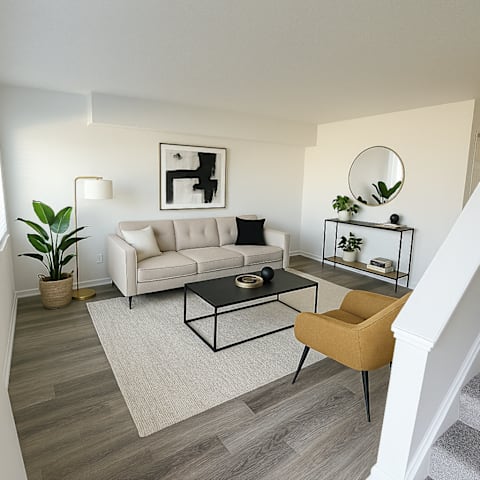 A living room with a white couch, a coffee table, and a yellow chair.