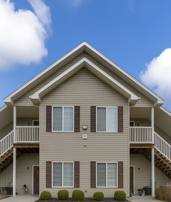 the front of a house with a porch and stairs