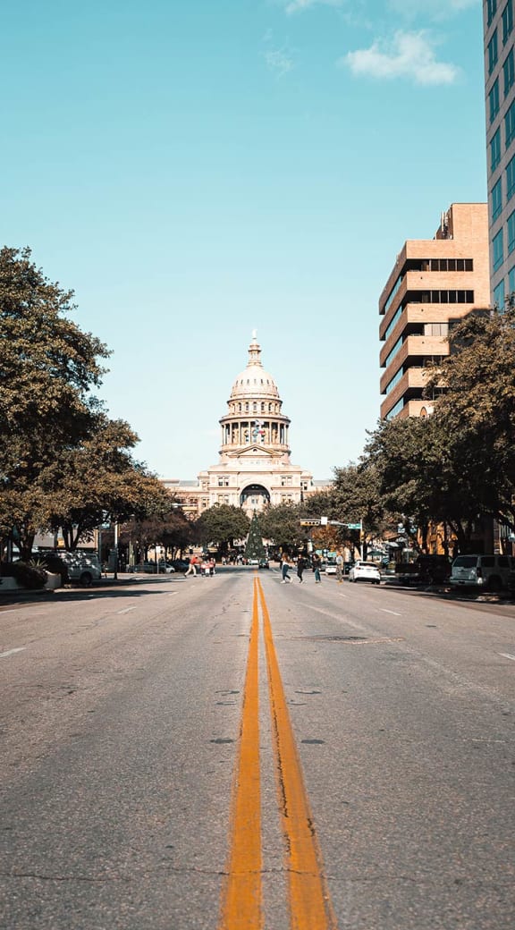 a city street with the capitol building in the background