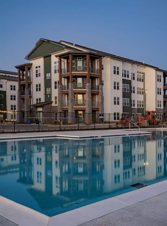 A modern apartment complex with a parking lot in front.
