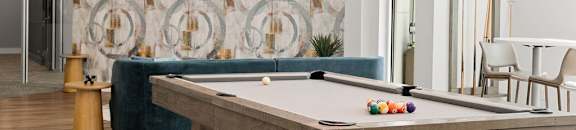 A pool table in a room with a television and a sofa.