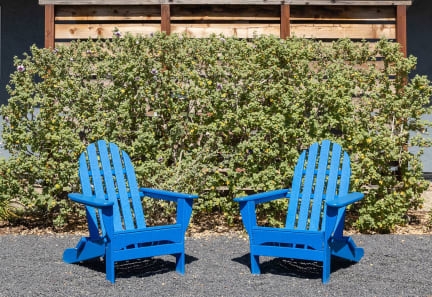 two blue chairs sitting in front of a building