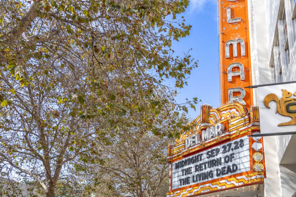 a city street with a theater sign on the side of a building