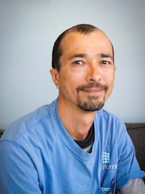 A man in a blue shirt with a logo on it.