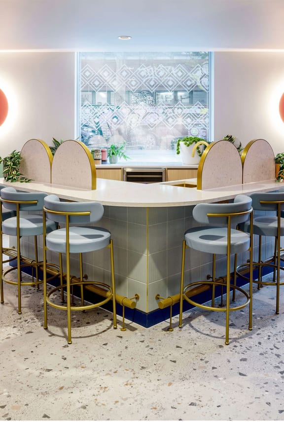 a long counter with high chairs in a restaurant with a window