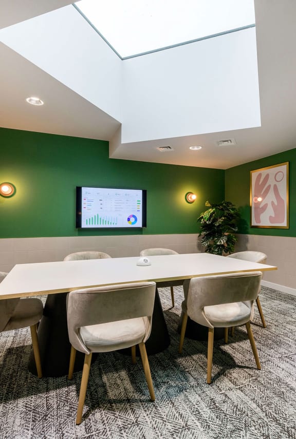 a conference room with green walls and a white table and chairs