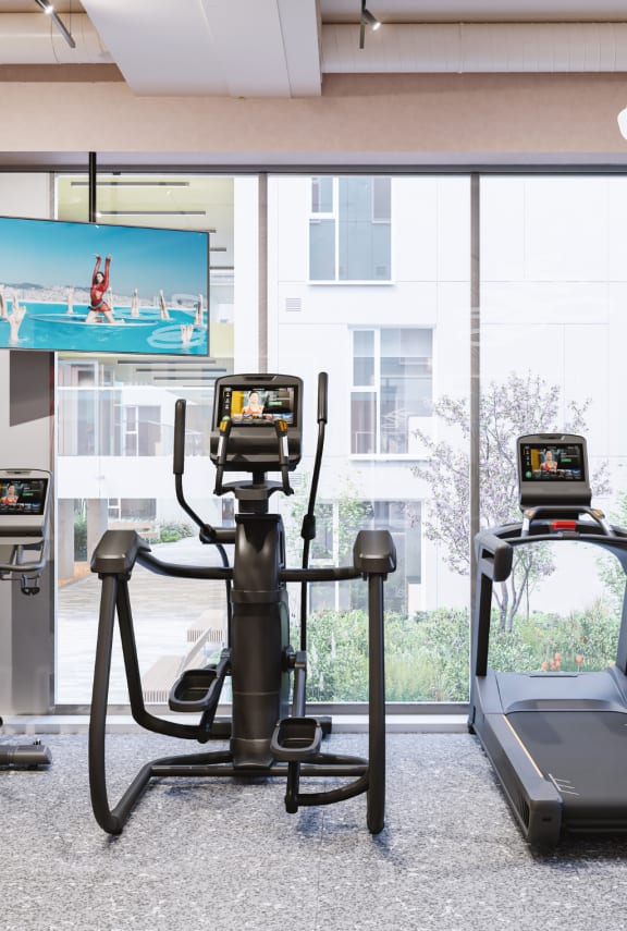 a gym with luggage on the floor and exercise machines