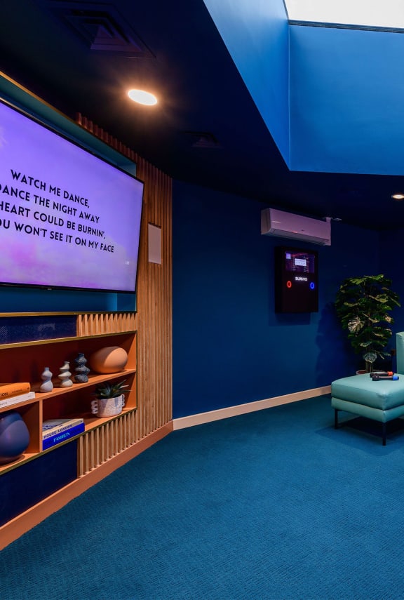a blue room with a projection screen and a blue bench
