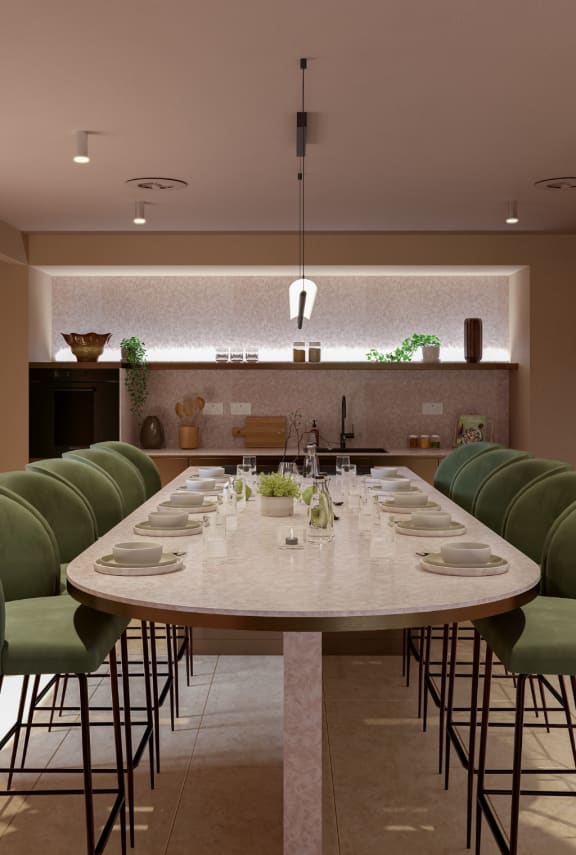 a long marble table in a restaurant with green chairs