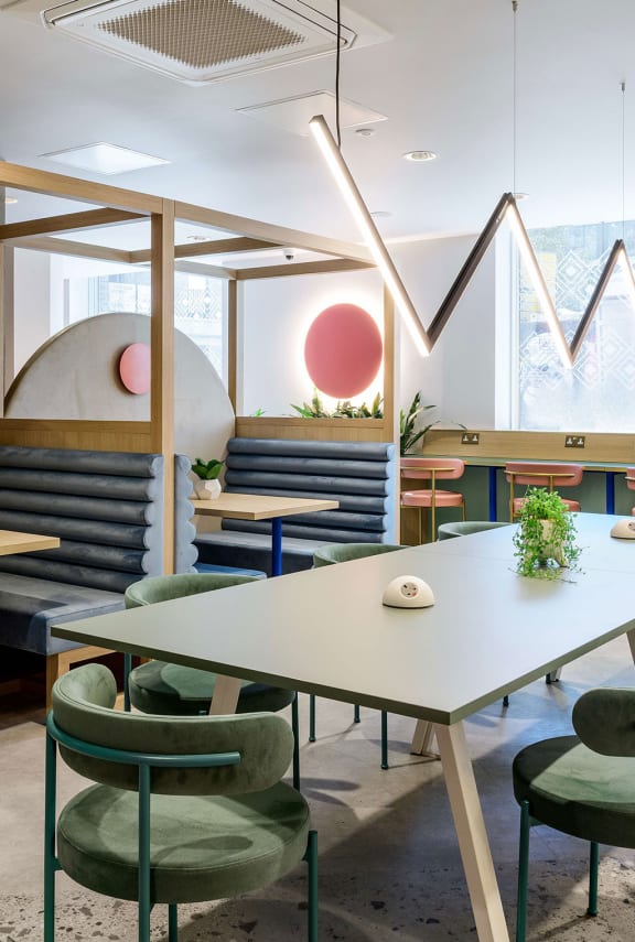 a restaurant with tables and chairs and geometric shapes on the wall