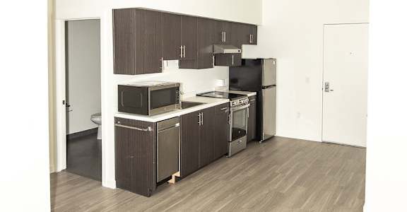 A kitchen with wooden floors and white walls.