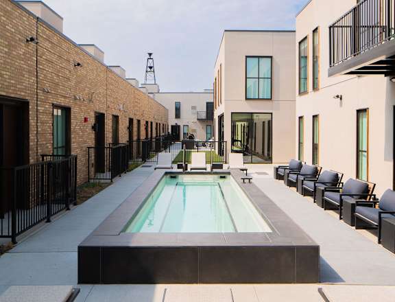 A modern courtyard with a pool and seating area.