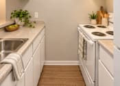 Thumbnail 10 of 11 - A kitchen with white cabinets and a stove top oven at Lifestyle at Shreveport in Shreveport, LA, 71109.