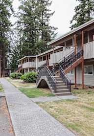 an apartment building with stairs and a sidewalk