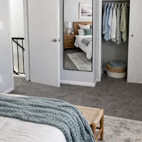 A bedroom with a bed, a wardrobe, and a mirror.
