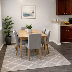 A dining room with a table set for four.